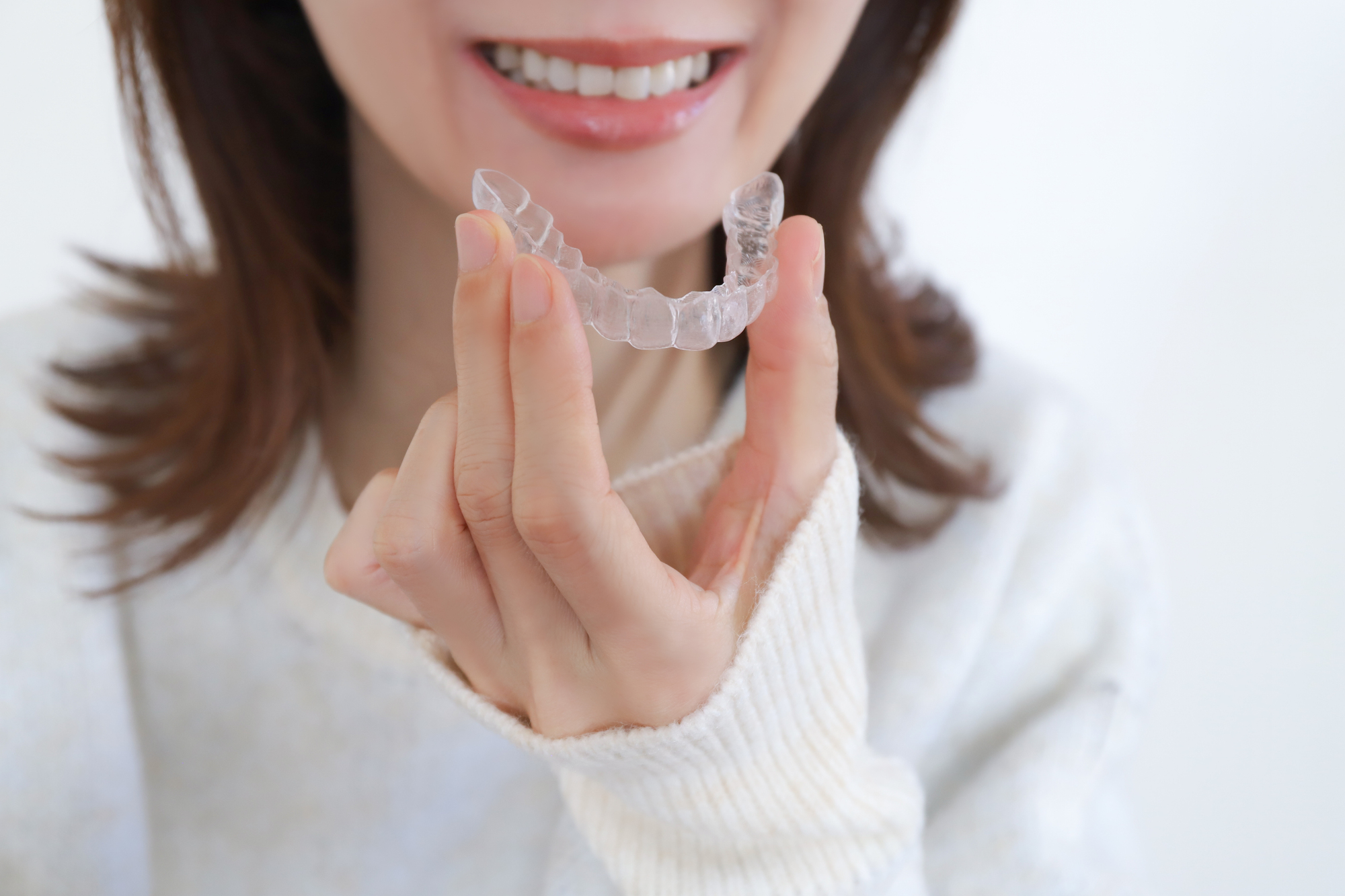 マウスピース型矯正装置を持つ女性